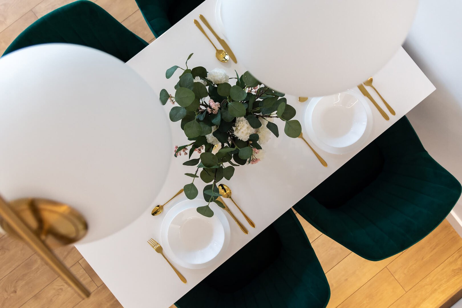 biały stół z zielonymi krzesłami home staging